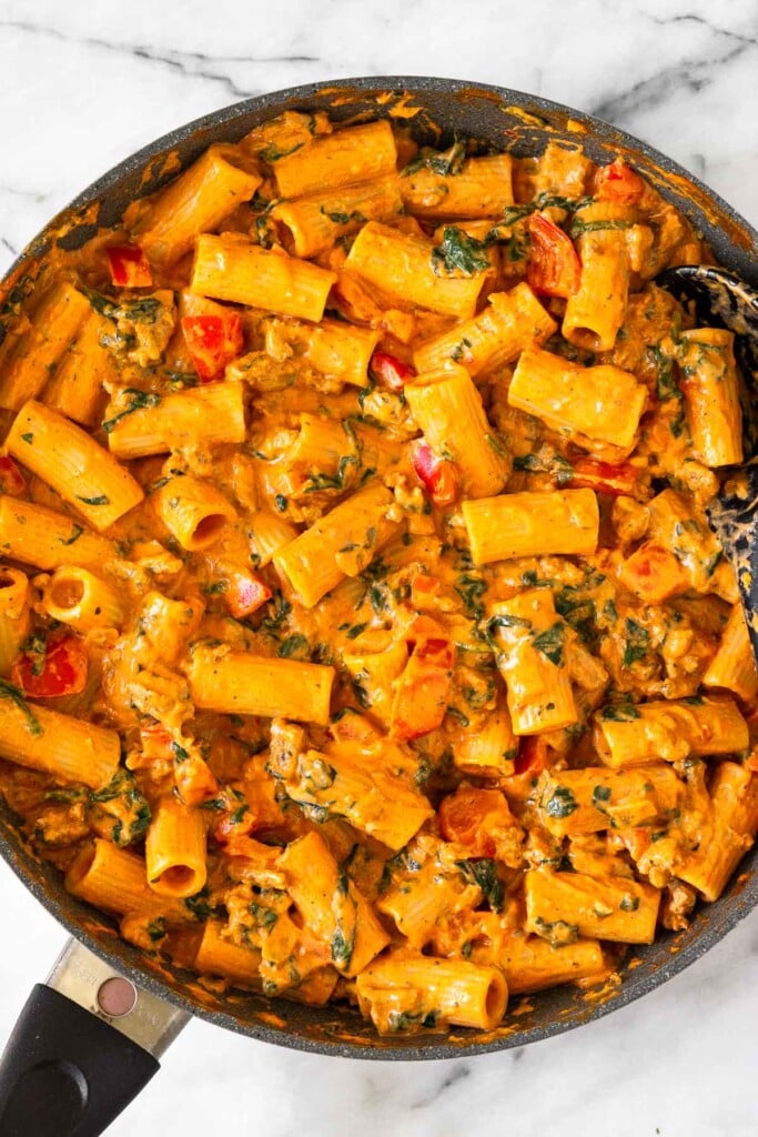 Large skillet filled with pasta, ground turkey, and veggies all tossed in a creamy red sauce.