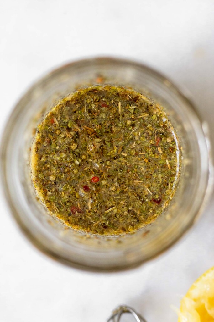 A small glass jar filled with marinade.