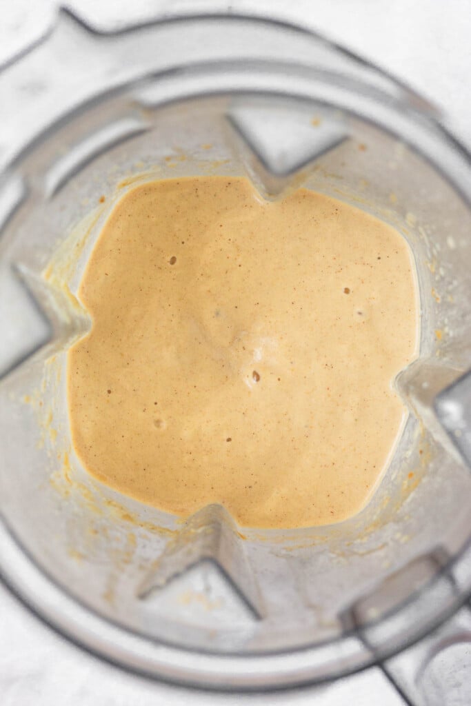 Overhead shot of a thick peanut butter banana smoothie in a blender.
