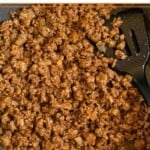 Ground beef taco meat in a large skillet with a spatula in it.