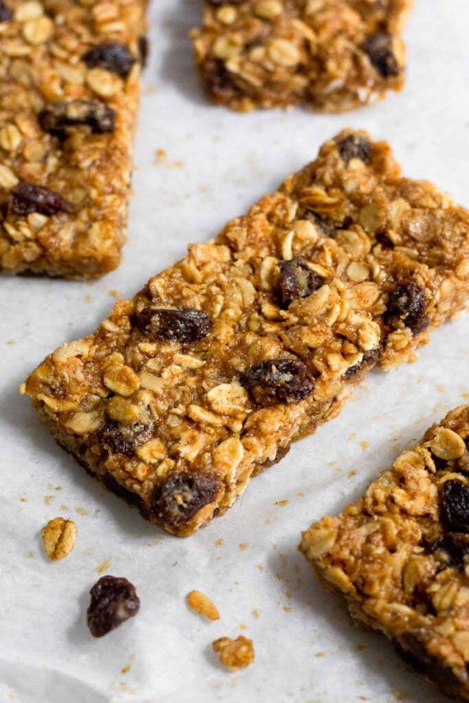 Oatmeal raisin protein bar on parchment paper. There are a more bars surrounding it.