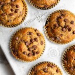 Overhead shot of a banana protein muffins with chocolate chips in a muffin tin.