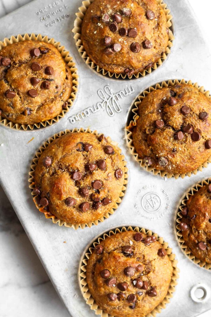 Overhead shot of a banana protein muffins with chocolate chips in a muffin tin.