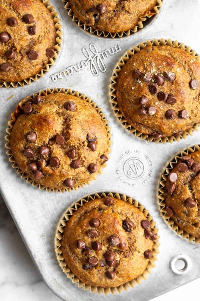 Overhead shot of protein muffins with chocolate chips in a muffin tin.