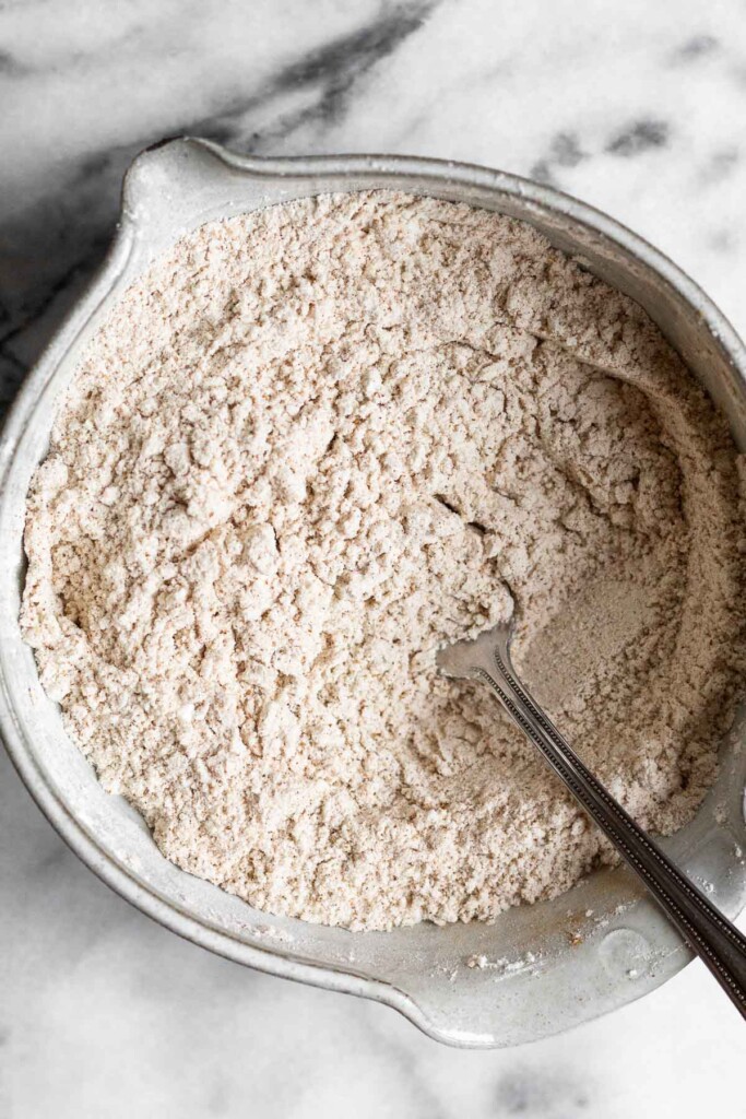 An overhead shot of a bowl with flour and spices mixed together. A fork is also in it.