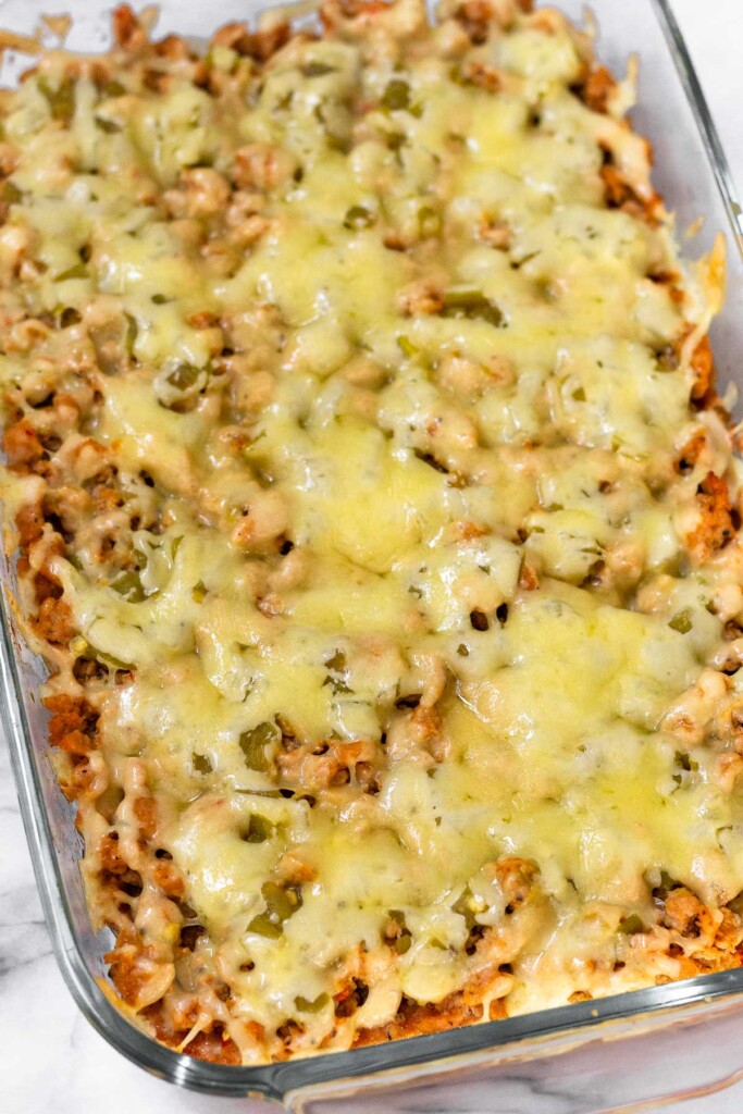 Melted cheese overtop ground meat and beans in a baking dish.