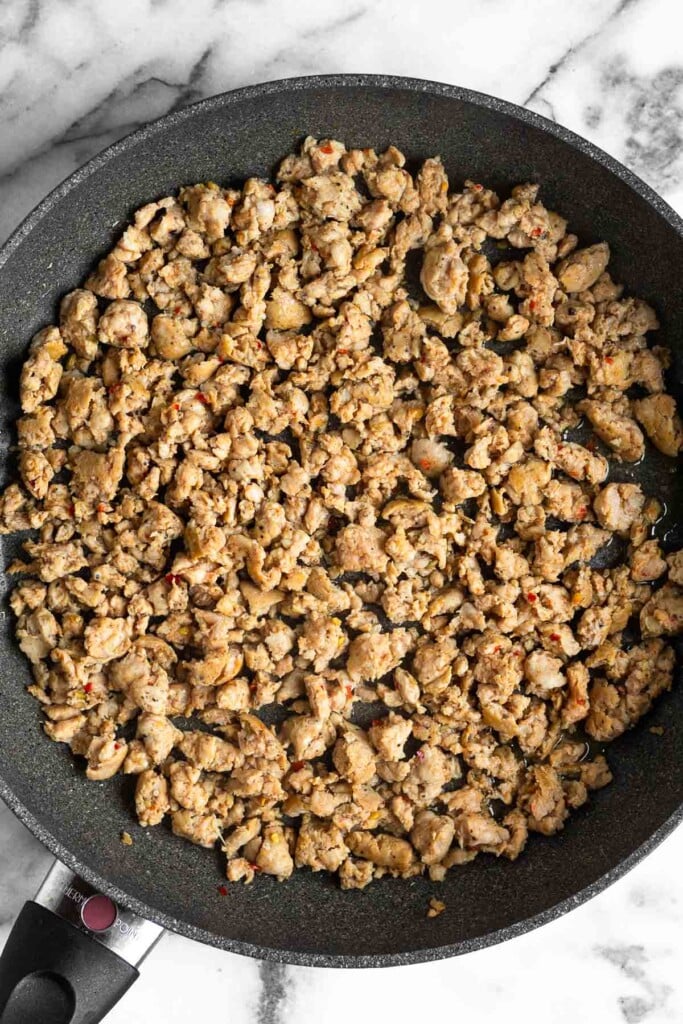 Large skillet filled with sautéed ground meat.