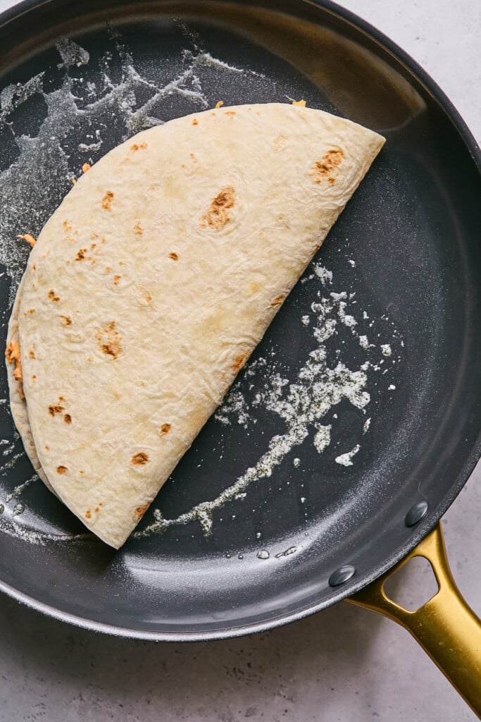 Quesadilla cooking in a large skillet.