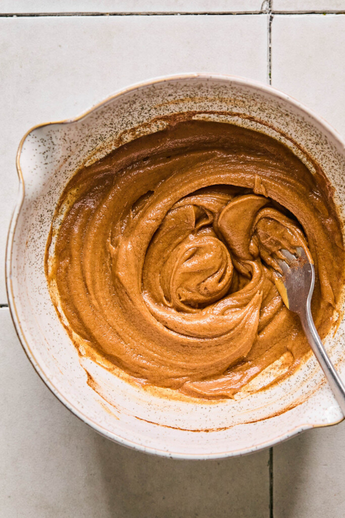 Peanut butter mixture in a mixing bowl with a fork in it.