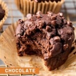 Chocolate banana protein muffin on a cooling rack with a bite taken out of it. There are more muffins behind it.