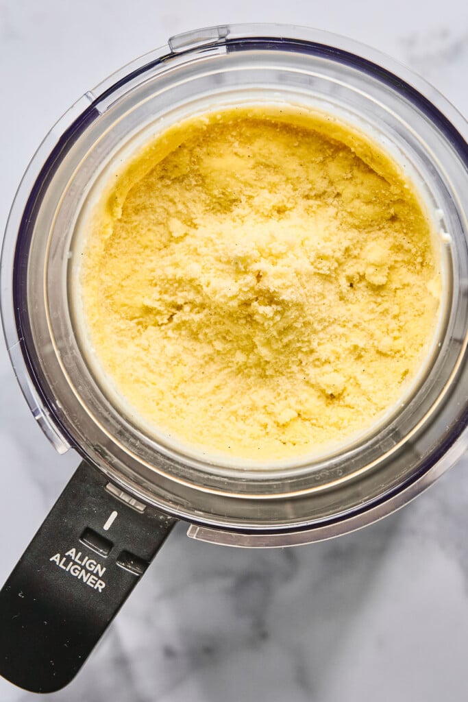 Powdery mango frozen yogurt mixture in the Ninja Creami before it is re-spun to make it creamy.