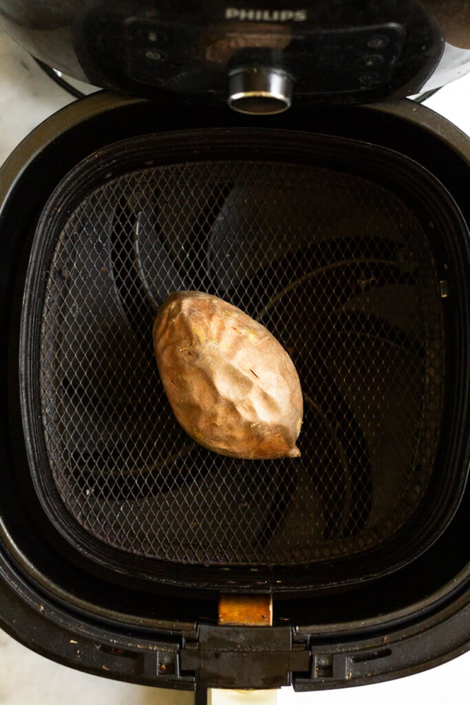 Small cooked sweet potato in an air fryer.