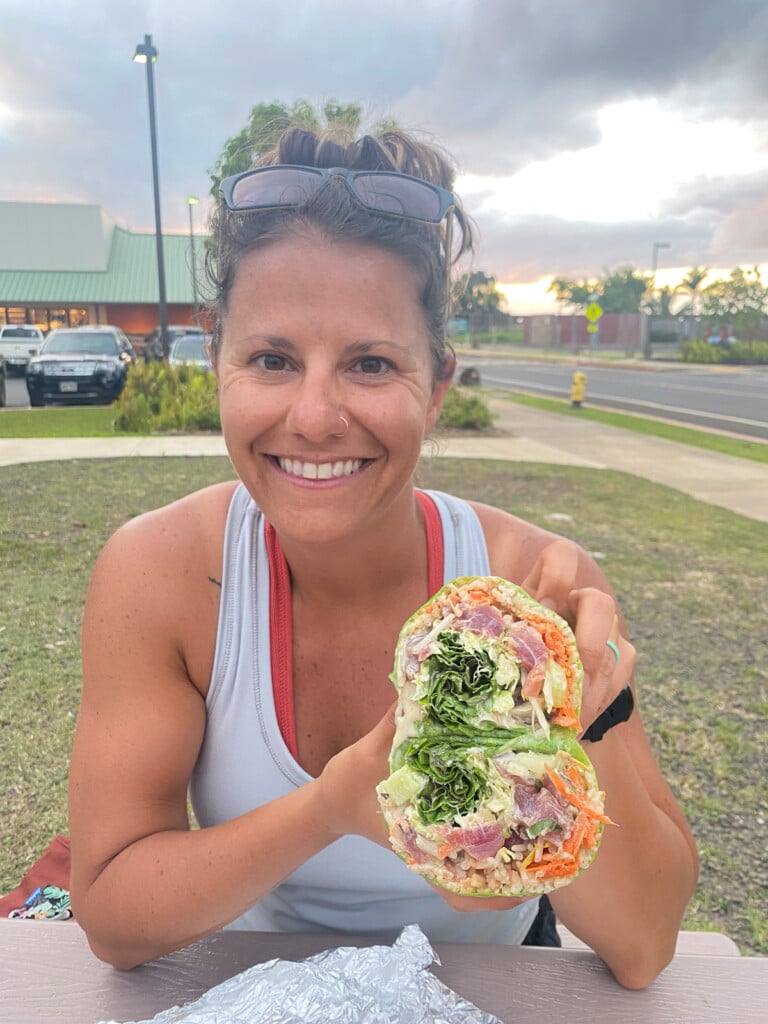 Woman smiling and holding a poke burrito.