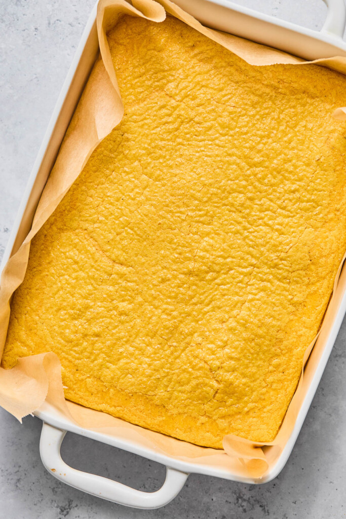 Baked eggs in a baking dish lined with parchment paper.