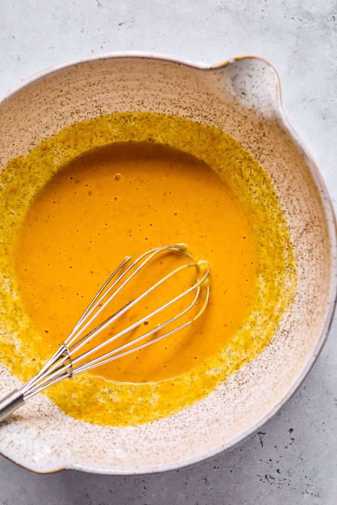 Wet batter in a bowl with a whisk in it.