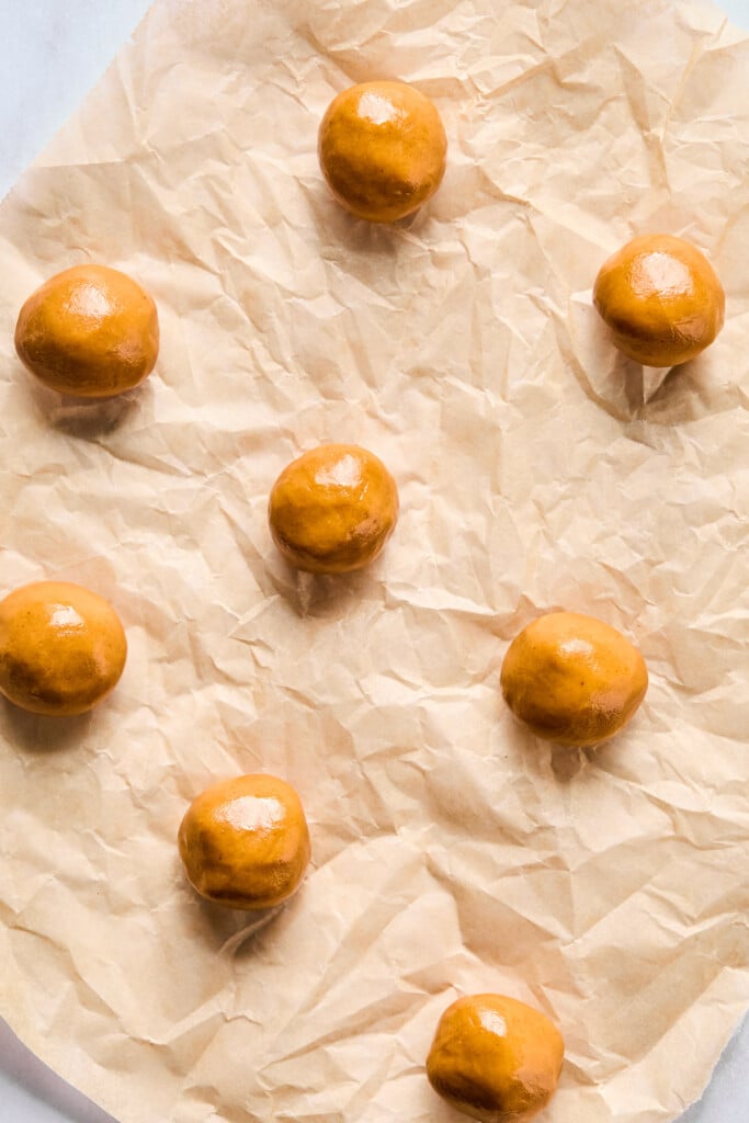 Balls of dough on parchment paper.