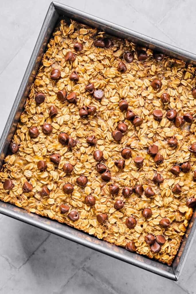 Banana oatmeal bake with chocolate chips and walnuts in a baking pan.