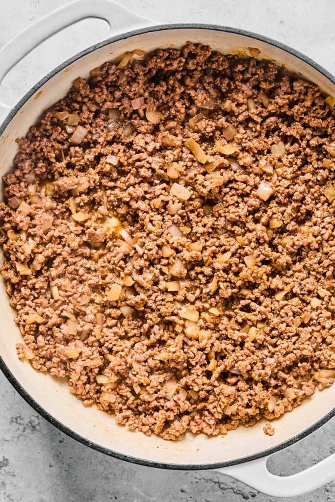 A close up of beef taco meat in a white dutch oven.